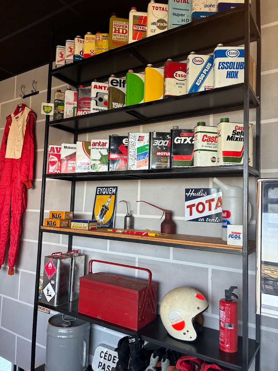 Combinaison de course, casque vintage et affiches dans le coin garage du Paddock