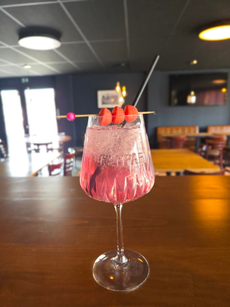 Cocktail rosé garni de fraises servi au Paddock